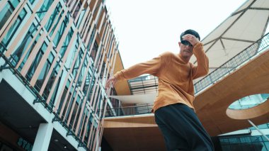 İspanyol dansçı hip hop tarzında dans ederken kameraya bakıyor. Genç ve çekici bir hippi müzik eşliğinde dans ediyor. Break dansçının hareket çekimi B-boy dansını gerçekleştirmek Açık hava sporu 2024. Hiphop.