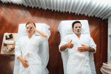 Kaplıca salonunun sakin, modern gündüz atmosferi, birkaç müşteri yüz maskesi takarak kendini yenilemeye çalışıyor. Yüz bakımı ve güzellik kozmetolojisi prosedürü. Sessiz.