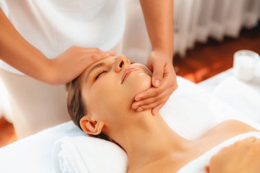 Kafkasyalı kadın stres önleyici kafa masajından ve lüks tatil beldesi ya da otel spa salonundaki modern ışık ortamında yüz güzelliği eğlencelerini şımartmaktan hoşlanıyor. Sessiz.