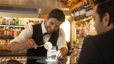 Akıllı barmen, lüks bir tezgahta arkadaşını beklerken limonlu cin kokteyli ikram ediyor. Barmen, canlı gece hayatı parti atmosferinde mükemmel hizmet veriyor. Vinosity.