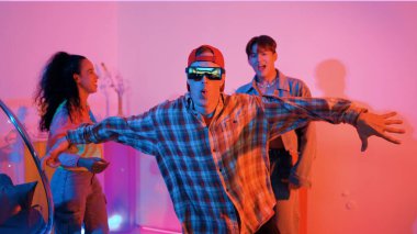 İspanyol hipster renkli kıyafetler giyer ve serbest stil müziğe el sallar. Profesyonel break dansçı neon ışıklarıyla ve modern stüdyo arkadaşlarıyla coşkuyla dans ediyor. Mutluluk.