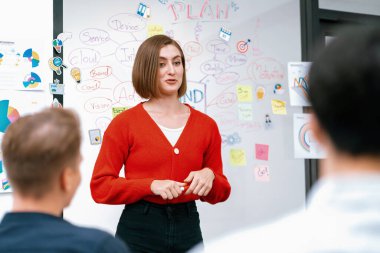 Profesyonel çekici kadın lider, modern iş toplantı odasında beyin fırtınası zihin haritalama istatistikleri ve renkli yapışkan notlar kullanarak yaratıcı pazarlama planını sunuyor. Tertemiz..