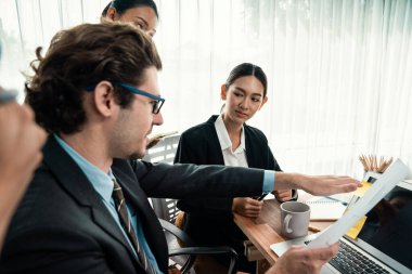 Modern ofis ortamında çalışan çeşitli etnik gruplardan çeşitli iş adamları. Üretken ve çok ırklı ofis çalışanları stratejik ticari pazarlama konusunda tartışmaya giriştiler. Habiliment