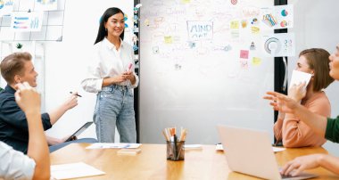 Genç ve güzel lider pazarlama stratejisini sunarken, uzman yatırımcı ve proje yöneticisi de yeni başlayan iş toplantısında iş performansını analiz etmeye çalışıyor. Çok ırklı bir grup. Tertemiz..