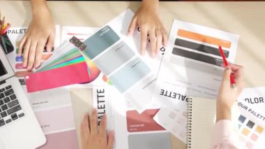 Üst görünüm yavaş çekim eli, grafik tasarımı için çalışan iki tasarımcının ya da tasarımcıdan yaratıcı kromatik konsültasyonda renk uygulaması arayan istemcinin masasının üzerinde. Değiştirilmiş