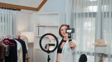 Kadın nüfuzlu kişi video görüntülerini canlı yayınlıyor. Kıyafetler sosyal medyada ya da blogda yer alıyor. Stüdyo ışıklandırmalı mutlu genç kız çevrimiçi pazarlama oturumu yayını için..