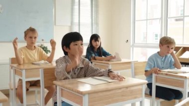 Sınıfta okuyan çok kültürlü çocuklarla çevrili öğretmenine sorup cevap veren zeki çocuk. Mutlu öğrenci birlikte çalışıyor, oy veriyor, gönüllü oluyor, hocayı arıyor. Pedagoji.