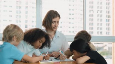 Çizim kitabında işaret kullanarak çeşitli öğrencilerin ve zeki öğretmen çizimleri ve boyamaları mutlu olsun. Çok kültürlü, zeki bir öğrenci yetenekli beyaz bir eğitmenle konuşurken çizim kitabı kullanıyor. Etkinlik.