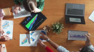Yetenekli iş adamlarının pazarlama stratejisi planlarken finansal haritaya bakması. Bilgi analiz etmek ve toplantı odasında rapor yazmak için laptopta çalışan bir grup insan. Cemaat.