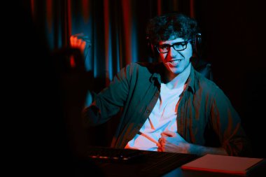 Genç oyun flaması takımı, Esport ile birlikte neon ışıklı odada kulaklık takarak online dövüş kazanan oyuncuları topluyor. Bir sonraki seviyeye rakip kazanmak için strateji planı uyguluyorum. Toplayıcı.