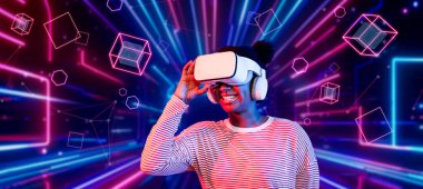 Çevresindeki geometrik şekle bakan kız metaevrende yüzüyor. Sanal dünyaya erişen mutlu genç ya da oyuncu VR kulaklık ve artırılmış gerçeklik teknolojisi kullanıyor. Teknoloji yeniliği. Yaratıcılık.