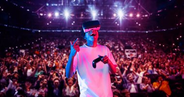 Yetişkinlerin elinde joystickle VR gözlükleri varken stadyumda arka planda bulanık oyunlar oynamaktan zevk alıyorlar. Afrikalı adam kontrol etmeyi ve artırılmış gerçeklik teknolojisini kullanmayı seviyor. Yaratıcılık.