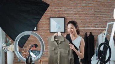 Kadın nüfuzlu kişi video görüntülerini canlı yayınlıyor. Sosyal medya ya da blog. Stüdyo ışıklandırması olan mutlu genç bir kız pazarlama için internet üzerinden yayın yapıyor..