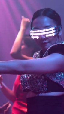 Bir grup insan disko gece kulübünde DJ 'in sahnede çaldığı müzikle dans ediyor. Yeni yıl partisi ve gece hayatı konsepti .