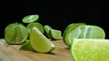 Yakın plan, canlı bir dilim taze kireç kırsal bir ahşap kesme tahtasının üzerinde duruyor. Tazelik ve canlılık yayıyor. Kesme tahtasına konmuş yeşil limon diliminin yarı saydam zarları. Geliştirilebilir.