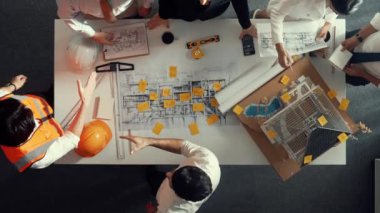 Yetenekli mühendis ekibinin proje planına bakarken konuştuğu en üst seviye görüntü. Birlikte çalışan ve mühendislik inşaatı için plan yapan bir grup akıllı iç mimar. Hizalama.