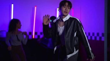 Kameranın önünde dans eden yetenekli break dansçı farklı arkadaşları pop ya da hip hop müziği dinlemek için arkada dans ediyor. Çekici performans ekibi kameraya doğru hareketli hareketler sergiliyor. Mutluluk.