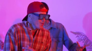 Break dansçı takımının modern stüdyoda pembe ışıkla dans etmesini kapatın. Çok kültürlü insanlar moda kıyafetleri giyerek hip hop müziğine geçiyorlar. Çılgın, komik bir ruh hali. Mutluluk.