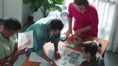 İnşaat inşaatı sırasında akıllı inşaat mühendisi proje planının en üst görünümü. Mimarla iç mimar birlikte çalışırken dizüstü bilgisayar kullanarak planı kontrol ediyorlar. Sempozyum.