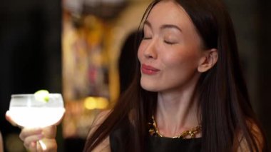Gülümseyen güzel bir kadın Margarita kokteylinin tadını çıkarıyor. Lüks bir barda arkadaşlarla ya da çiftlerle canlı sohbetler yapıyor. Canlı bir gece kulübünde bir an yaratıyor. Vinosity.