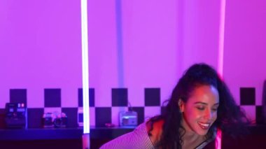 Stüdyoda mor ışıkla sokak dansı yapan İspanyol sokak dansçılarına yakın çekim. Profesyonel sanatçı şık kumaşla enerjik bir hareket sergiler. Çılgın, komik. Yarı vücut. Mutluluk.