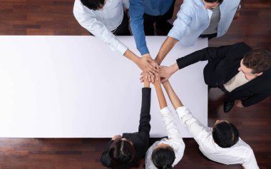 Panorama afişi çeşitli ofis çalışanlarından oluşan bir grup toplantı masasında el ele verecek. İş sinerjisi ve iş yerinde üretken bir takım çalışması. İş adamlarının birlik ve beraberliği. Tedbirli