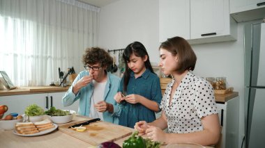 Mutlu baba yemek pişirirken müziğe geçiyor ve modern mutfakta öğle yemeği hazırlıyor. Aktif baba, sebze ve mutfak gereçleri ile çevrili sağlıklı yemek ya da salata yaparken şarkıyla dans ediyor. Pedagoji.