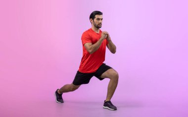 Vücut uzunluğunun tamamı atletik ve sportif genç bir adam tarafından izole edilmiş arka planda egzersiz pozisyonunda çekilmiştir. Sağlıklı aktif ve vücut bakımı yaşam tarzı.