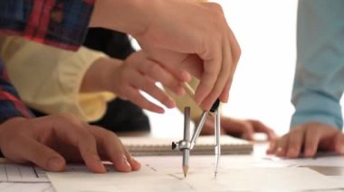 Mimarlar veya akıllı mühendislerin videosu mimari ofisindeki inşaat doğruluğu için taslak üzerinde ölçüm aracı, bölücü ve kalem el yazısı detaylarını kullanır. Eline odaklan. - Yakın çekim. Tanımlama.