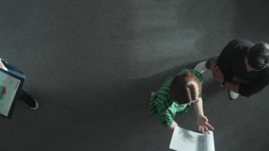 İş kadınına tepeden bakan bakış açısı ve pazarlama stratejisini toplantıda dururken yatırımcıya açıklamak. Lider karar verirken borsa çizelgesine ve veri analizine bakıyor. Cemaat.