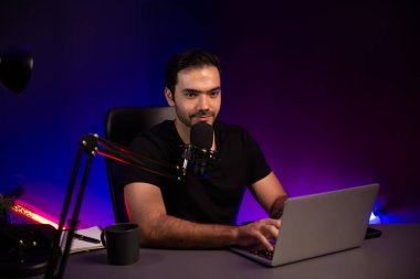 Yayıncı, fanclub dinleyicisiyle mikrofon kullanarak konuşuyor. Mor neon ışıklı modern stüdyoda yaratıcı olumlu düşünce konseptiyle canlı yayında finansal sorunları tartışıyor. Tahmin et..