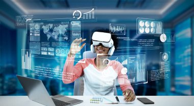 Masada ödev yaparken yapay zeka kullanarak metaevreleri birbirine bağlayan dizüstü bilgisayar ve artırılmış gözlük kullanan bir kız. Öğrenci holograma bakıyor ve bulanık ofiste oturuyor. Yaratıcılık.