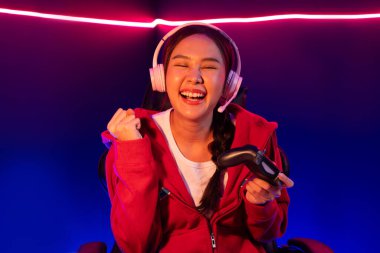 Neon odada kulaklık takan yetenekli Esport takım oyuncularını yumruklayarak oynayan güzel Asyalı kız flamasının sunucu kanalı. Taktik.