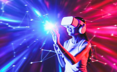 Zeki bir kadın, metaevreni birbirine bağlayan VR kulaklık takan neon ışıklarla çevrili duruyor. Gelecekteki siber uzay topluluğu teknolojisi. Sanal gerçeklik objesini kullanan zarif bir kadın. Halüsinasyon.