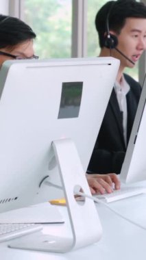 Ofiste çalışan kulaklık takan işadamları uzak müşteri ya da meslektaşlarını desteklemek için çalışıyorlar. Arama merkezi, tele pazarlama, müşteri destek acentesi telefon görüşmesinde hizmet sunar.