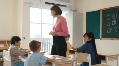 Sınıfta çeşitli çocuklar sınıf ödevlerini yaparken, Kafkasyalı öğretmen sınıfta yürüyor ve öğrenci ödevlerini kontrol ediyor. Çeşitli zeki öğrenciler ilkokulda ders veriyor ve not alıyor. Pedagoji.