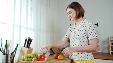 Çekici beyaz anne salata yapmak için taze sebze doğruyor. Mutlu enerjik akıllı anne kahvaltıda sağlıklı yemek pişirirken modern mutfakta çalışıyor. Yemek hazırlama konsepti. Pedagoji.