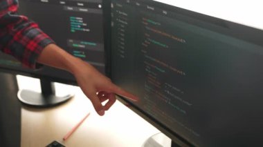 Yavaş çekimde geri uç veya yazılım geliştirici yöneticisi ekibini monitörde hata ayıklama ve karmaşık kod algoritmalarını çözmede yeni uygulama programı geliştirmede denetliyor. Filizlenen