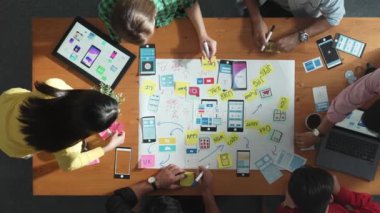 Profesyonel geliştirici ekip Ux Ui tasarımı fikrini zihin haritası kullanarak paylaşıyor. Bir grup iş adamının beyin fırtınası yapmak ya da cep telefonu arayüzü uygulamasını planlamak için birlikte çalıştıklarını görüyoruz. Cemaat.