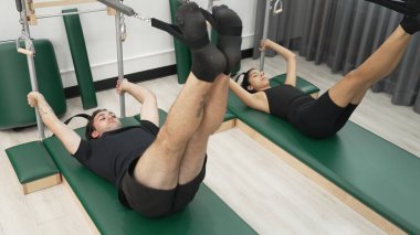 Bir grup müşteri, çekirdek dayanıklılığını ve bacak bağını geliştirmek için Cadillac reformatör makinesinde pilates egzersizleri yapıyor. Sağlıklı müşterilerin daha düşük poz verip kaldırma pozlarının üst görüntüsü. Sağlıklılık. Alışkanlık.