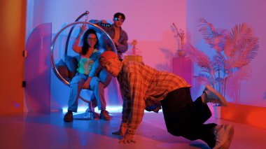 Stüdyoda gündelik kıyafetleri olan çok kültürlü bir arkadaş tezahürat yaparken mutlu hipster break dansları. Profesyonel sokak dansçısı hip hop ritmi ya da neon veya kurşun ışıkla kafiyeli bir şarkı söyler. Mutluluk.