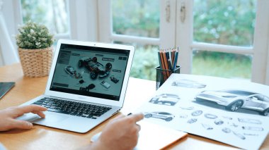 Araba tasarım mühendisi otomobil işi için otomobil prototipini ev ofisinde analiz ediyor. Otomotiv mühendisliği tasarımcısı dikkatle analiz ederek, dizüstü bilgisayarla araba tasarımında kusurlar ve iyileştirmeler buluyor.