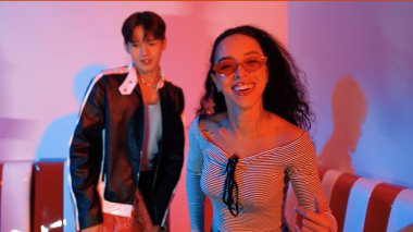 Çok kültürlü bir arkadaş birlikte dans ediyor ve hiphop müziği eşliğinde restoranda ya da kafede pembe neon ışıklı duruyor. Profesyonel sokak dansçıları grubu enerjik hareketler sergiliyor. Mutluluk.