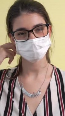 Genç bir kadın yüz maskesini çıkararak karantinanın sonunu ve COVID-19 'u kazanma konseptini gösteriyor. .