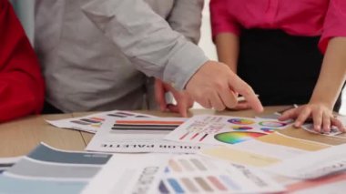 Tasarımcı ekibinin beyin fırtınası yaptığı ve grafik tasarımı için renk seçimi yaptığı el kapanışı ya da tasarım bürosunda krom danışmanlığı için danışmanlık isteyen bir müşteri. Değiştirilmiş