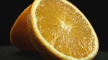 Portakal diliminin bir makrografi görüntüsü, parlak, izole edilmiş bir arkaplan üzerine yerleştirilmiş, narenciye cazibesinin görsel bir başyapıtı olarak gözler önüne seriliyor. Siyah arkaplanlı bir dilim portakal. Geliştirilebilir.
