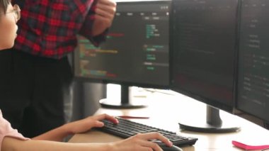 Yavaş çekimde geri uç veya yazılım geliştirici yöneticisi ekibini monitörde hata ayıklama ve karmaşık kod algoritmalarını çözmede yeni uygulama programı geliştirmede denetliyor. Filizlenen