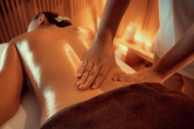 Yakından kadın müşteri strese karşı spa masajını rahatlatıyor ve lüks otel ya da otelde sıcak mum ışığında güzellik teniyle eğleniyor. Sessiz.