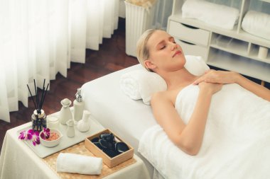 Kafkasyalı kadın müşteri stres önleyici spa masajının keyfini çıkarıyor ve lüks otel ya da oteldeki gündüz açık ortam güzellik salonunda güzellik teniyle eğleniyor. Sessiz.