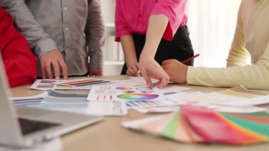 Grafik tasarımı için beyin fırtınası yapan ve renk seçimi yapan tasarımcı ekibinin yavaş çekim çekimi veya tasarım bürosunda krom danışmanlığı için danışmanlık isteyen bir müşteri. Değiştirilmiş